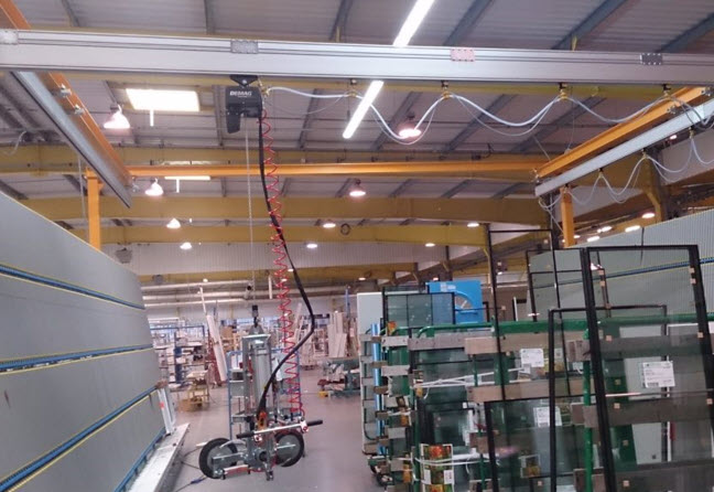 Palonnier à ventouse de capacité 200kg, pneumatique avec basculement sous poutre roulante alimentant 2 lignes de production.